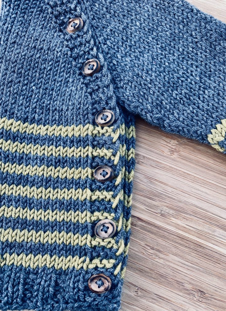 side view of baby cardigan grey with yellow stripes and wood buttons