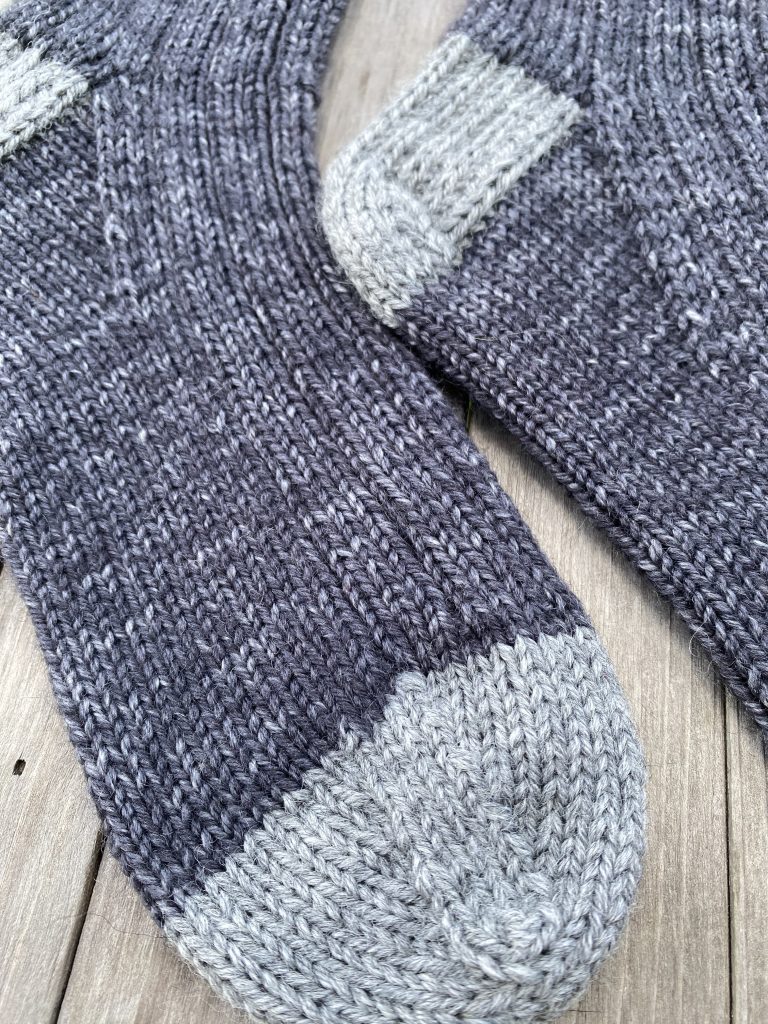 close up of gray drops fiesta knit sock on wood background